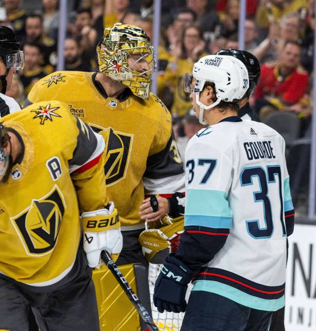 Golden Knights goaltender Adin Hill (33) talks with a referee as Seattle Kraken center Yanni Go ...