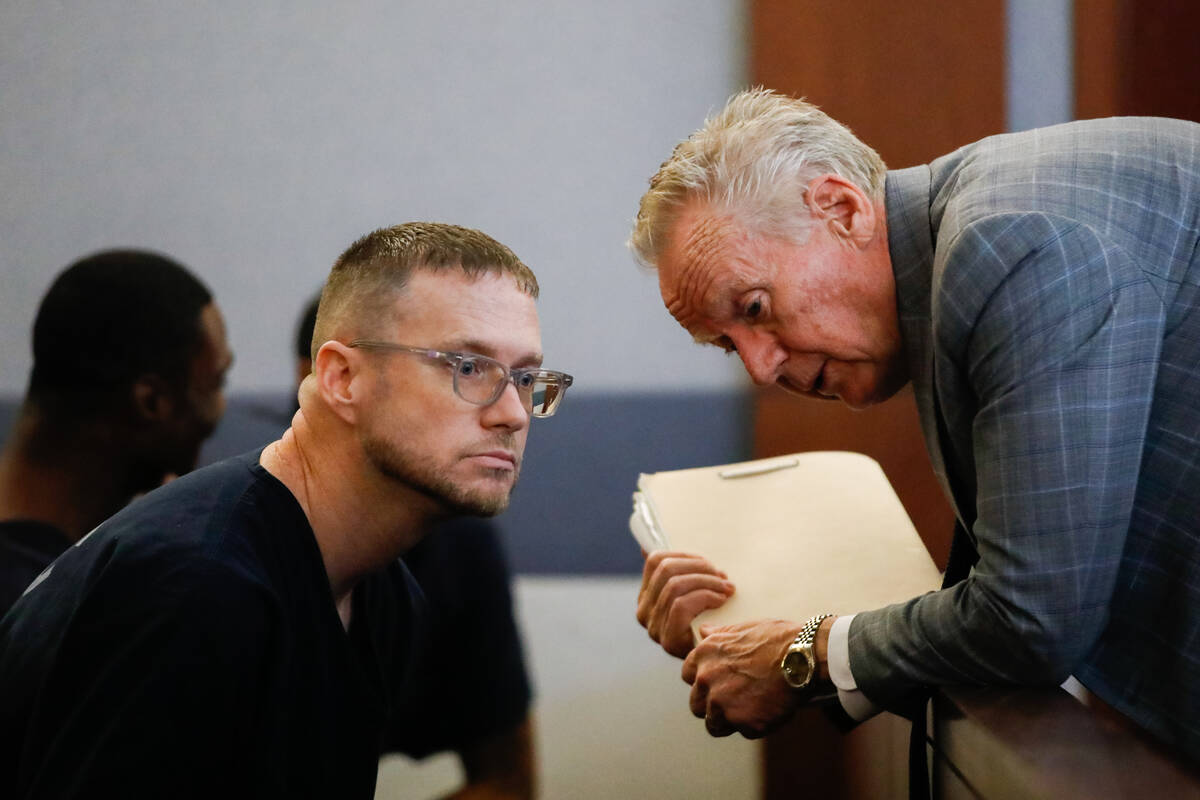 Patrick Byrom speaks with defense attorney Peter James Christiansen during a court hearing at t ...