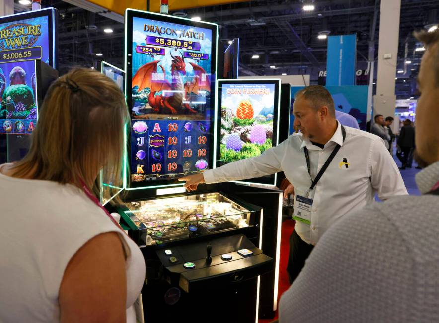 Todd Finco of Aries Technology demonstrates how Dragon Hatch game is played on CP3 cabinet at G ...