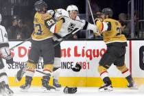 Golden Knights defenseman Alec Martinez (23) holds back Kings right wing Hayden Hodgson (57) wh ...