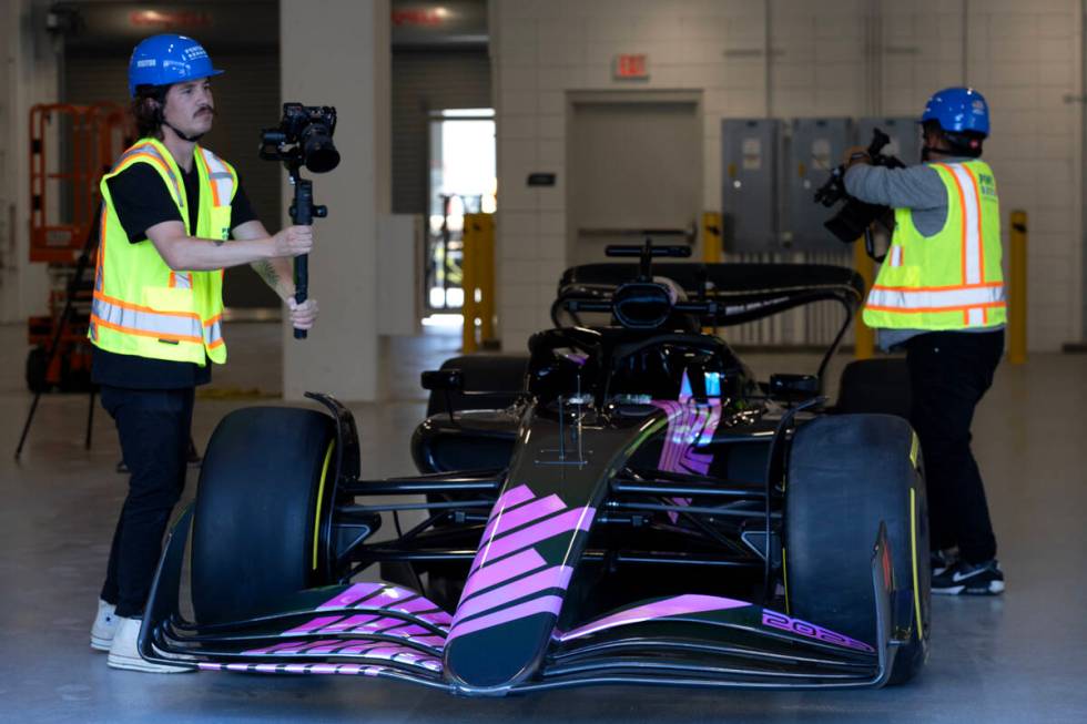 Videographers film a Formula One show car during a news conference at the F1 Pit Building on Tu ...