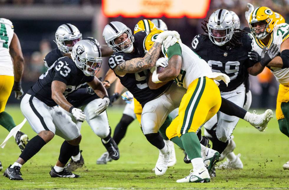 Raiders defensive end Maxx Crosby (98) stops Green Bay Packers running back AJ Dillon (28) behi ...