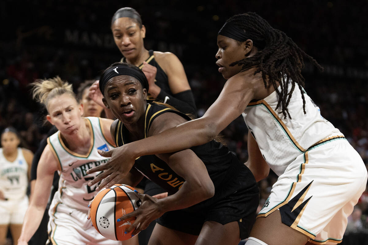 Las Vegas Aces guard Jackie Young (0) struggles for the ball against New York Liberty forward J ...