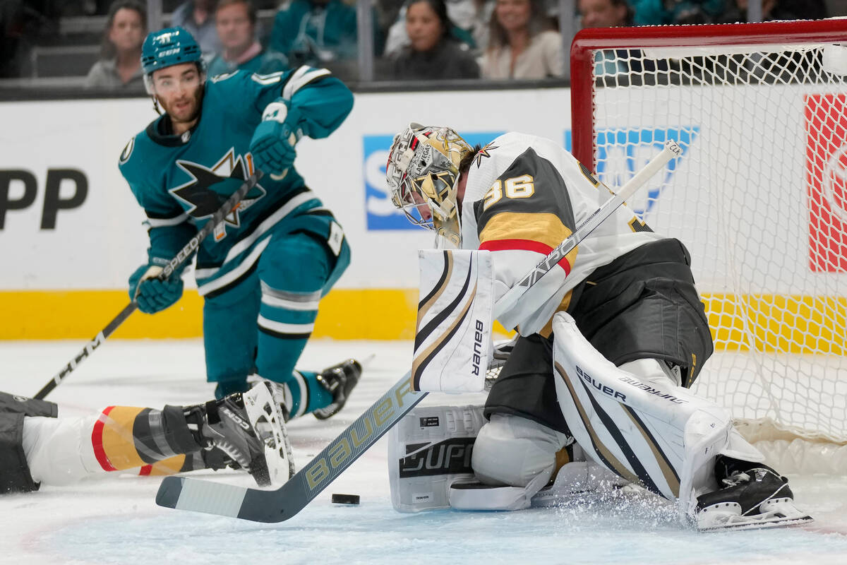 Vegas Golden Knights goaltender Logan Thompson, right, defends against a shot in front of San J ...