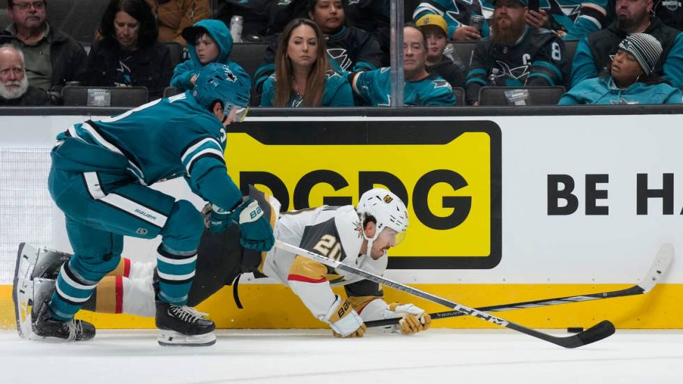 Vegas Golden Knights center Chandler Stephenson, right, reaches for the puck in front of San Jo ...