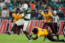 Miami running back Donald Chaney Jr. (2) avoids a tackle attempt by Bethune Cookman defensive b ...