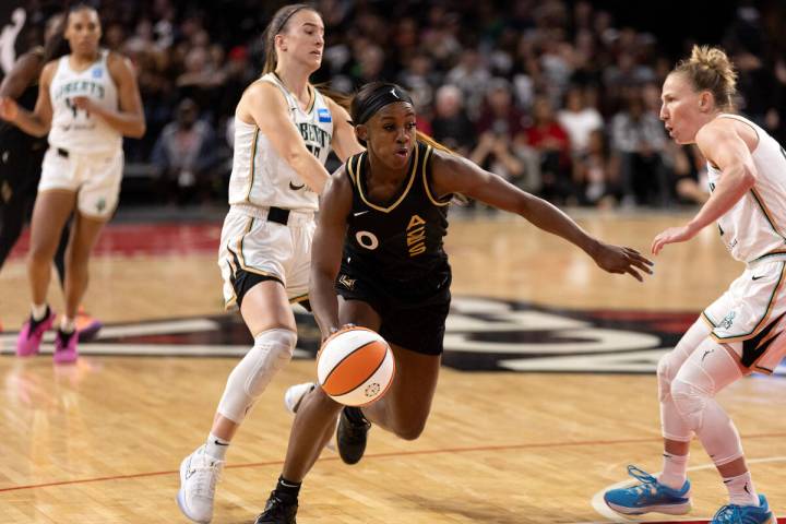 Las Vegas Aces guard Jackie Young (0) drives toward the hoop between New York Liberty guards Sa ...