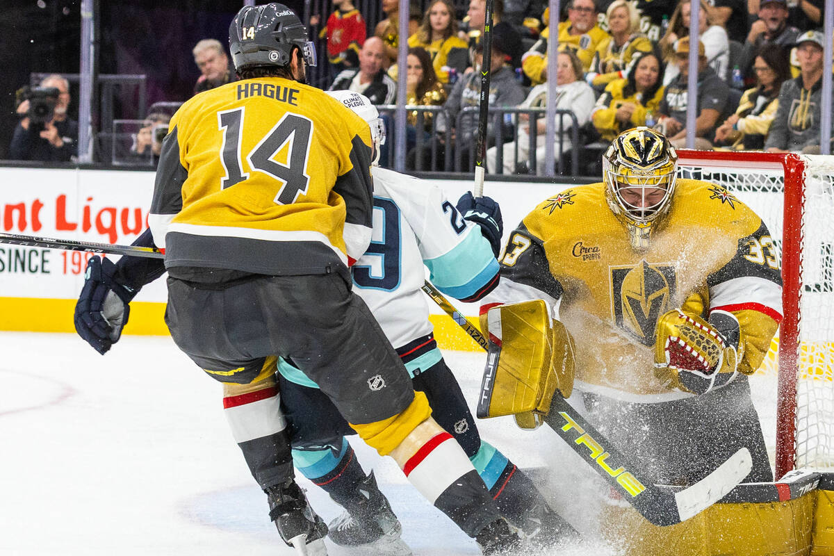 Golden Knights goaltender Adin Hill (33) holds onto a shot by Seattle Kraken defenseman Gustav ...