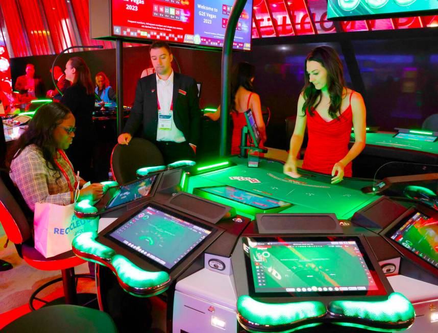 A conventioneer plays on Interblock Gaming's Smart Pit 5-seaters Blackjack table at G2E Las Veg ...