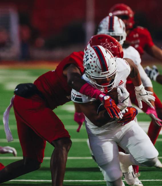 Liberty running back Isaiah Lauofo (3) runs the ball through Arbor View defenders during a game ...