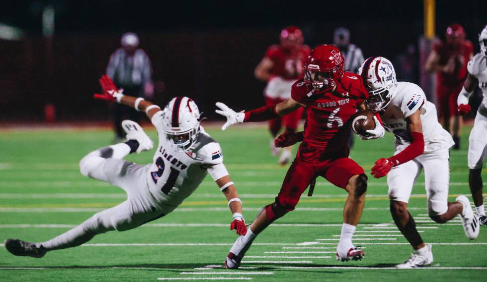 Arbor View wide receiver Jayden Williams (6) fends off Liberty cornerback Rylan Kan (21) as he ...