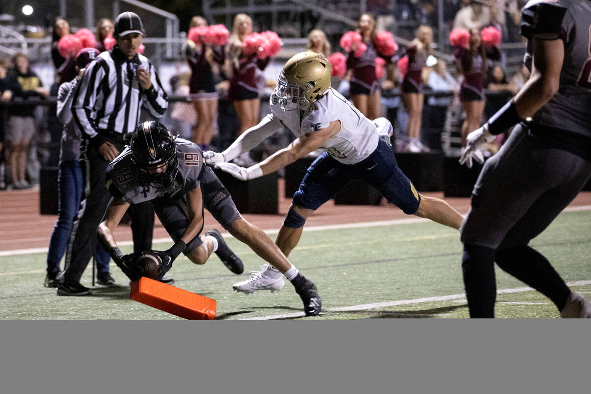 Faith Lutheran tight end Andrew O'Reilly (19) catches a touchdown pass but is knocked out of bo ...