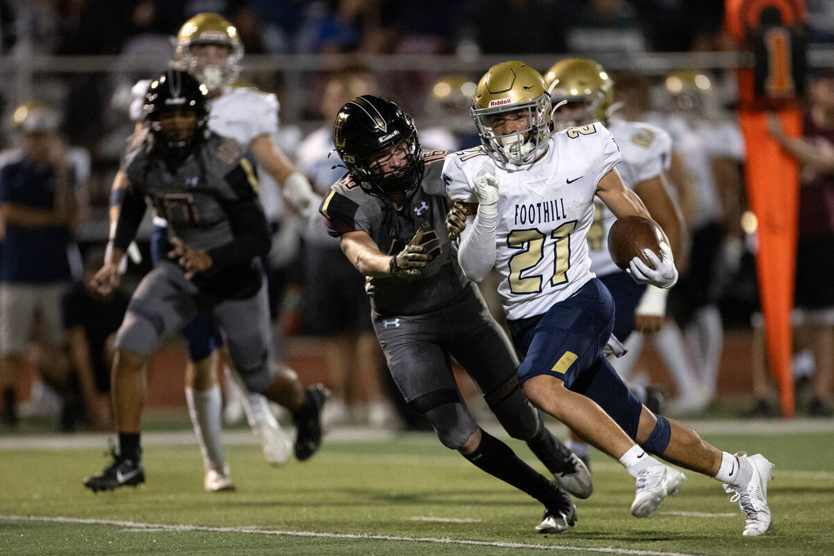 Foothill running back Avant Gates Jr. (21) rushes up the field while pressured by Faith Luthera ...