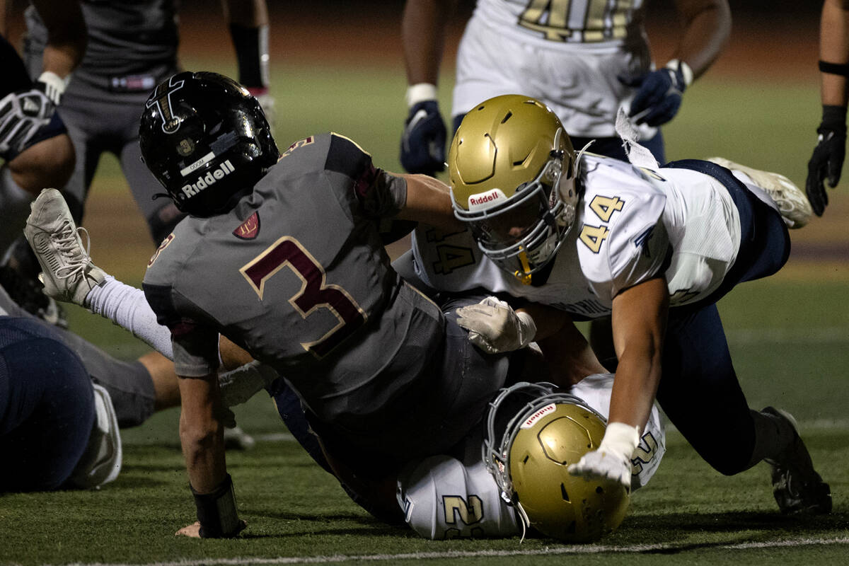 Foothill defensive end Teverae Berry (44) and strong safety Dayton Summers (23) tackle Faith Lu ...