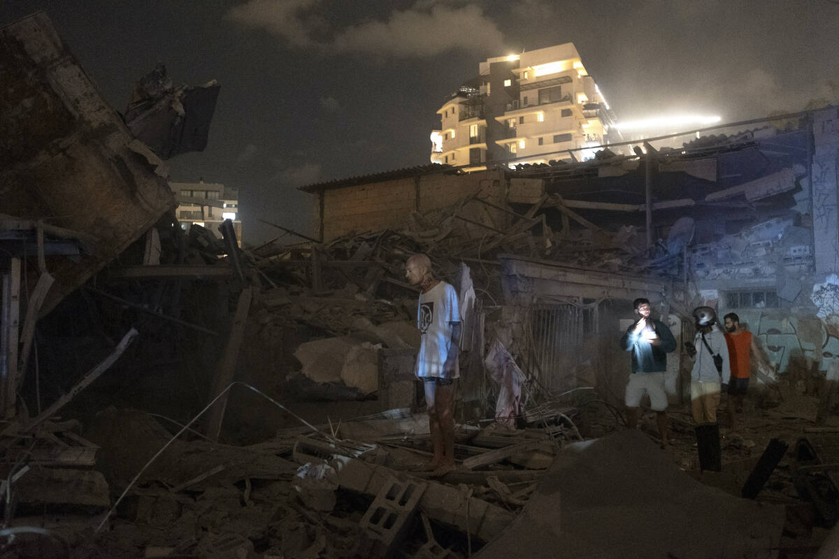 People look at the damage from a rocket fired from the Gaza Strip in Tel Aviv on Saturday, Oct. ...