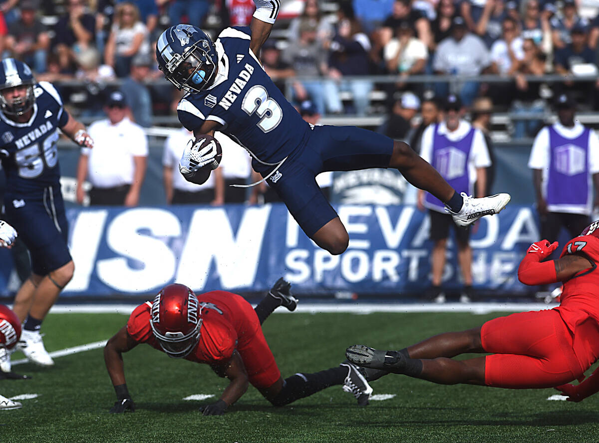 Nevada’s Jamall Bell gets hit by UNLV’s Kris Williams (17) and Rashod Tanner (41) while ret ...