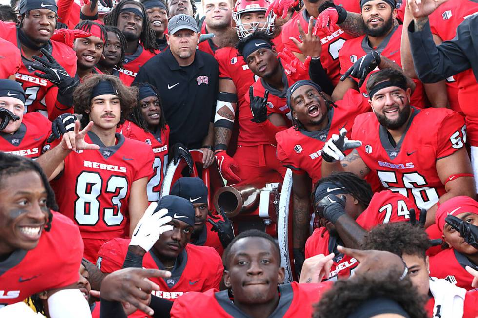 UNLV players celebrate their victory over Nevada by claiming the Fremont Cannon at Mackay Stadi ...