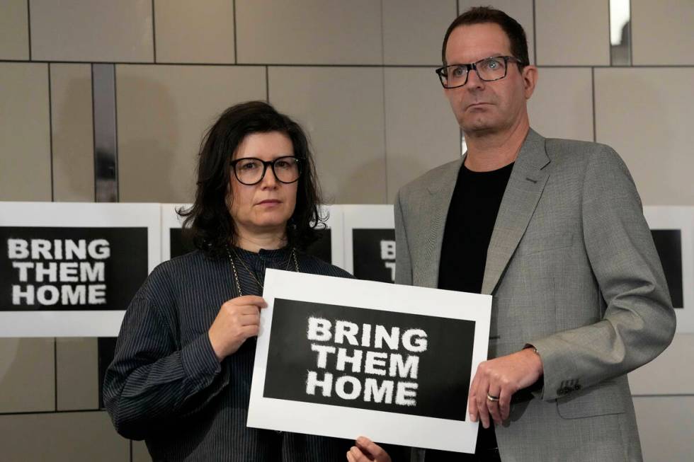 Sharon Lifschitz, left, and Noam Sagi pose for photographers after a press conference of Britis ...