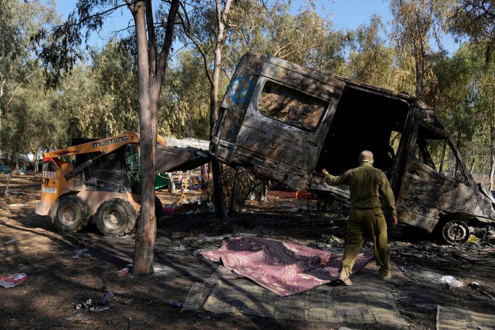 Israeli military removes a burned van from the site of a music festival near the border with th ...