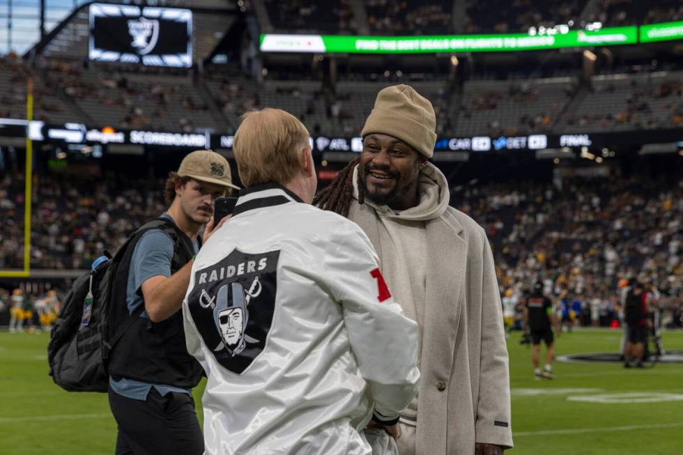 Former Raiders running back Marshawn Lynch, right, shakes owner Mark Davis’ hand before ...