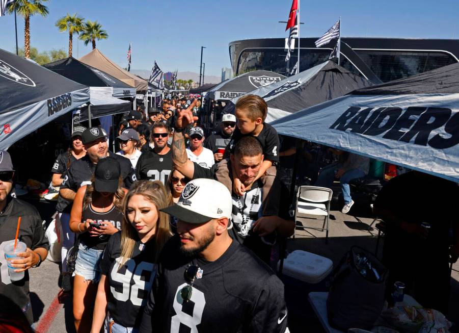 Raiders fans tailgate outside Allegiant Stadium before the start of an NFL football game betwee ...