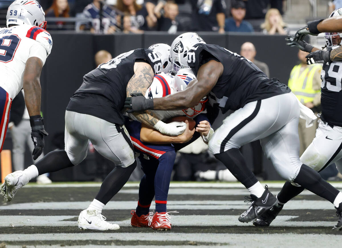 New England Patriots quarterback Mac Jones (10) is sacked by Raiders defensive end Maxx Crosby ...