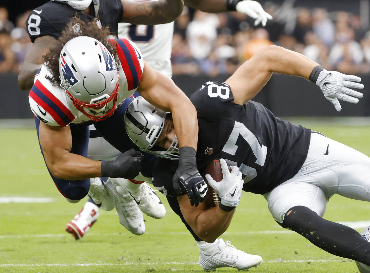 Raiders tight end Michael Mayer (87) is tackled by New England Patriots linebacker Jahlani Tava ...