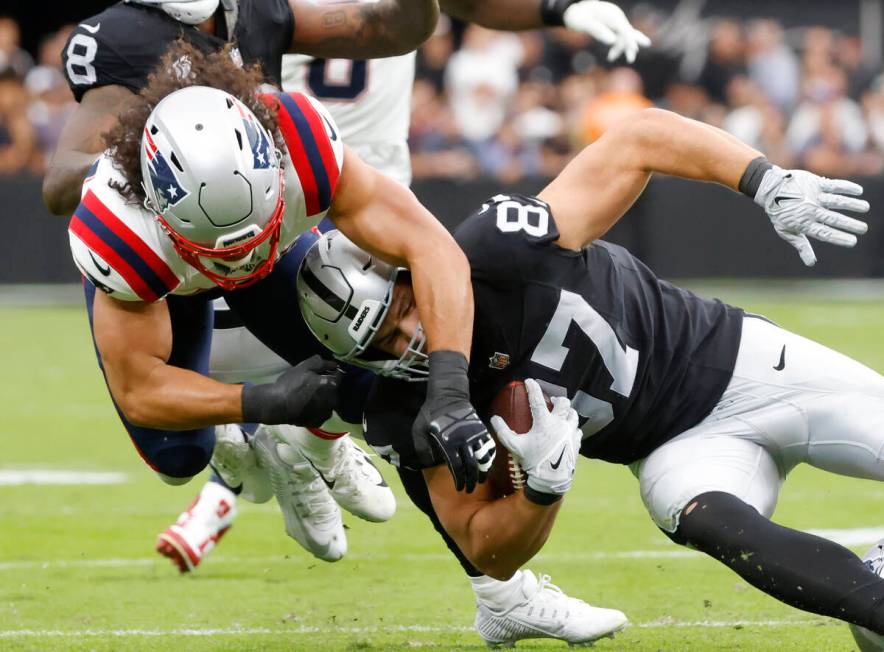 Raiders tight end Michael Mayer (87) is tackled by New England Patriots linebacker Jahlani Tava ...