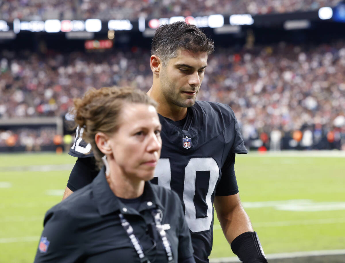 Raiders quarterback Jimmy Garoppolo (10) is escorted out of the field during an NFL football ga ...