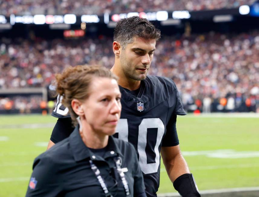 Raiders quarterback Jimmy Garoppolo (10) is escorted out of the field during an NFL football ga ...