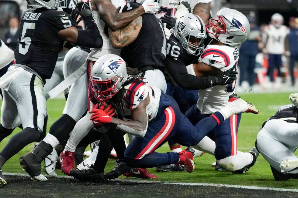 New England Patriots running back Rhamondre Stevenson, below, scores a touchdown during the sec ...