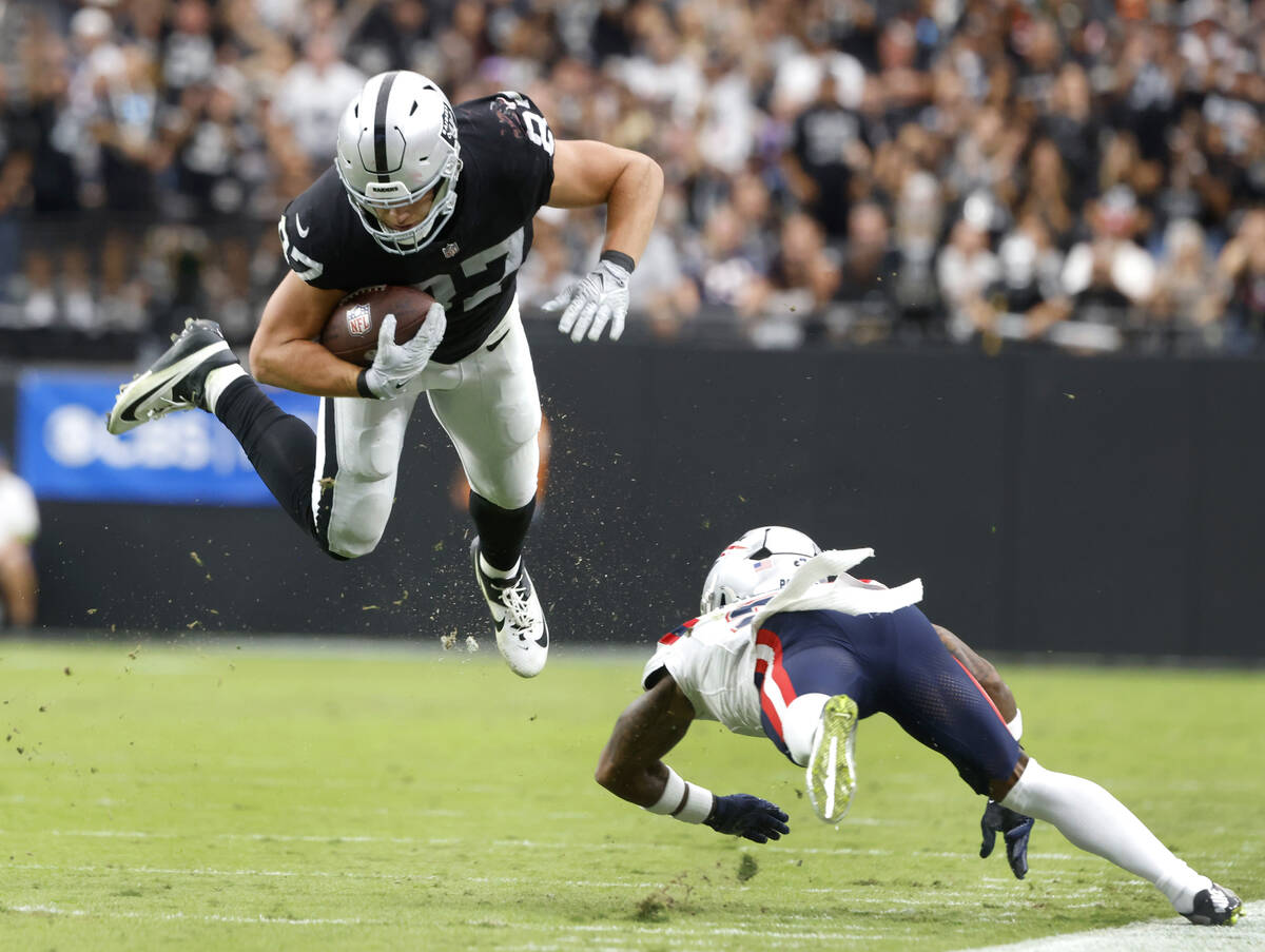 Raiders tight end Michael Mayer (87) leaps over New England Patriots cornerback Jalen Mills (2) ...