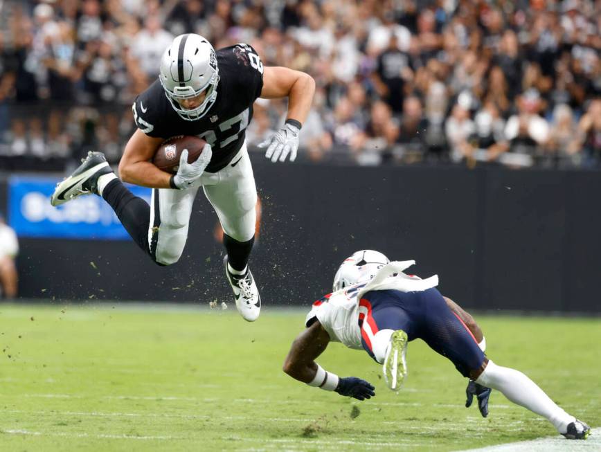 Raiders tight end Michael Mayer (87) leaps over New England Patriots cornerback Jalen Mills (2) ...