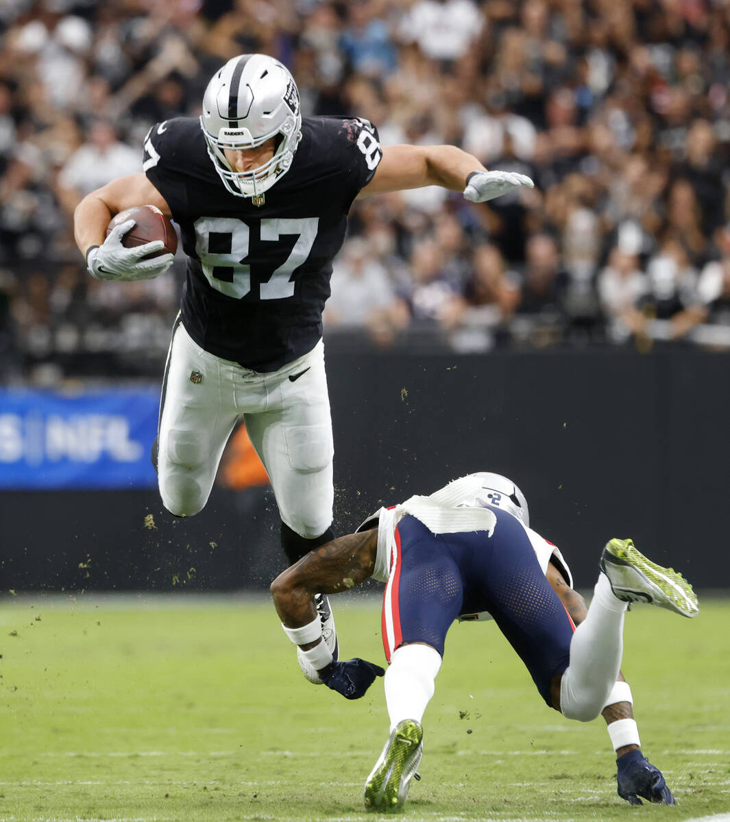 Raiders tight end Michael Mayer (87) leaps over New England Patriots cornerback Jalen Mills (2) ...