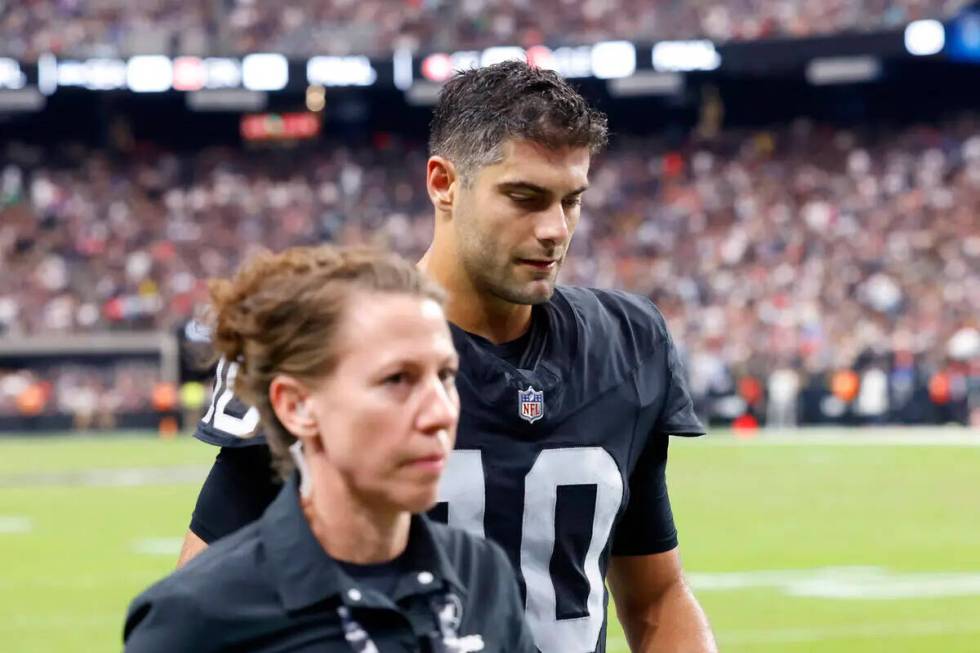 Raiders quarterback Jimmy Garoppolo (10) is escorted out of the field during an NFL football ga ...