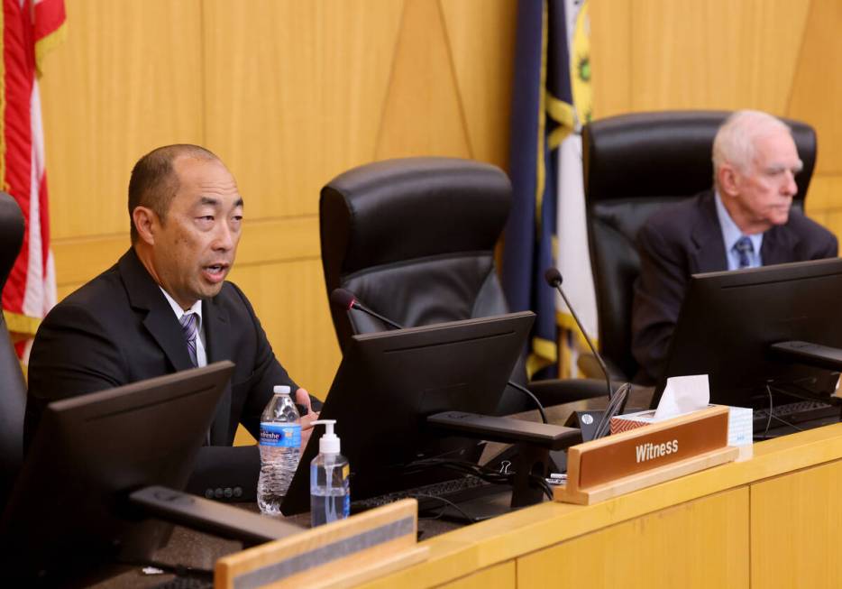 Henderson Police Detective Dennis Ozawa, left, speaks as Hearing Officer William Jansen listens ...