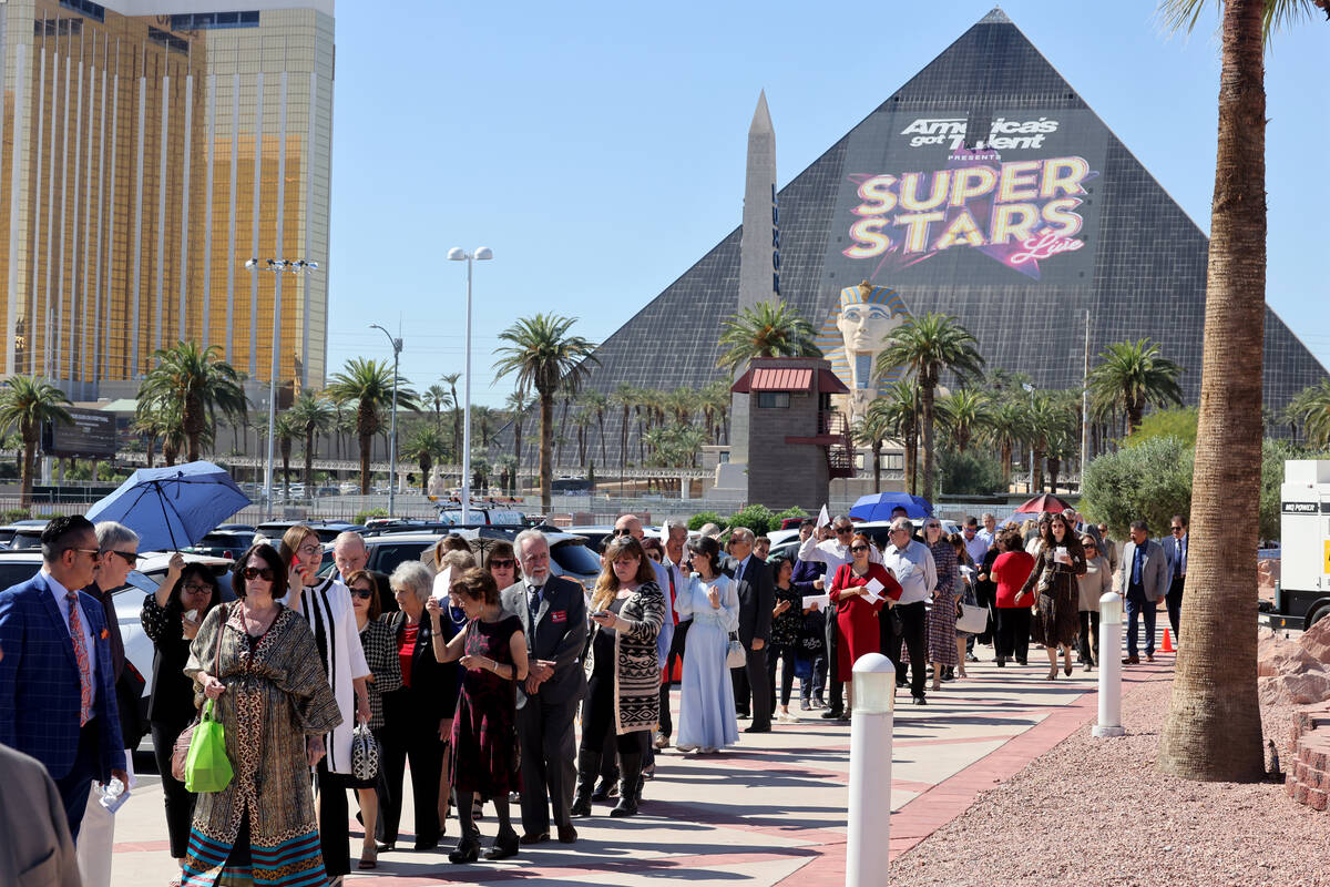 People wait in line for the imposition of the Pallium on Archbishop George Leo Thomas at a Mass ...