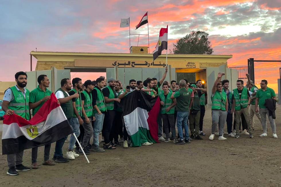 Volunteers of the humanitarian aid convoy for the Gaza Strip wave Egyptian and Palestinian flag ...