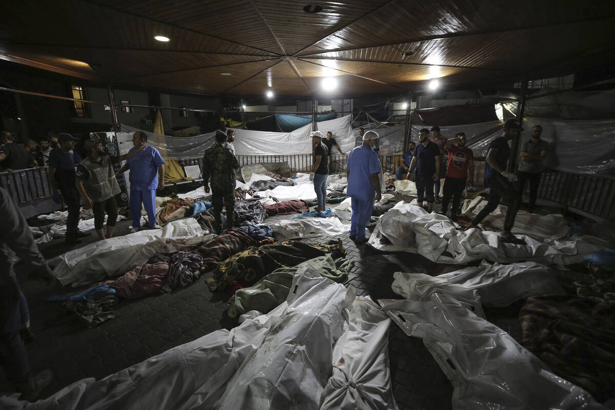 Bodies of Palestinians killed by an airstrike that hit the Ahli Arab hospital are seen gathered ...