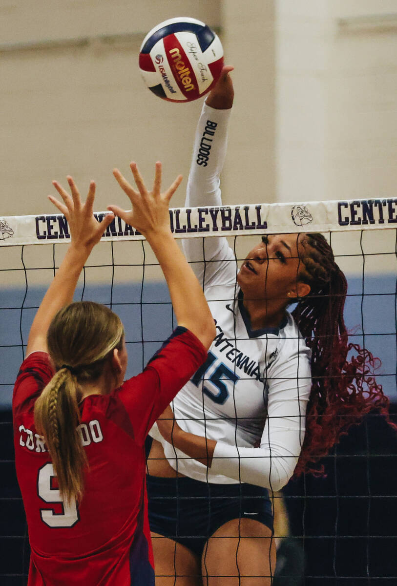 Centennial middle blocker Aliah Williams (15) hits the ball over the net during a game against ...