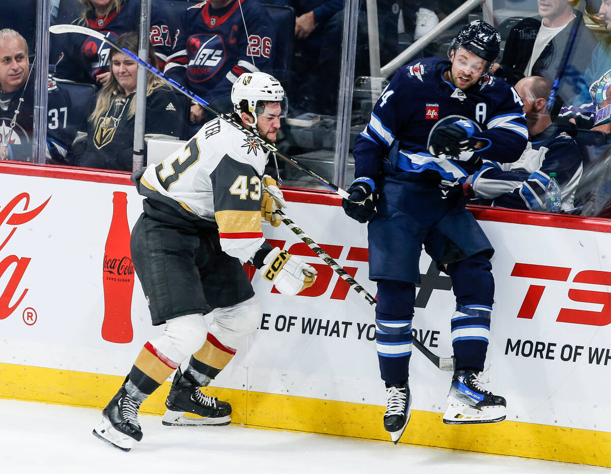 Winnipeg Jets' Josh Morrissey (44) and Vegas Golden Knights' Paul Cotter (43) collide during th ...