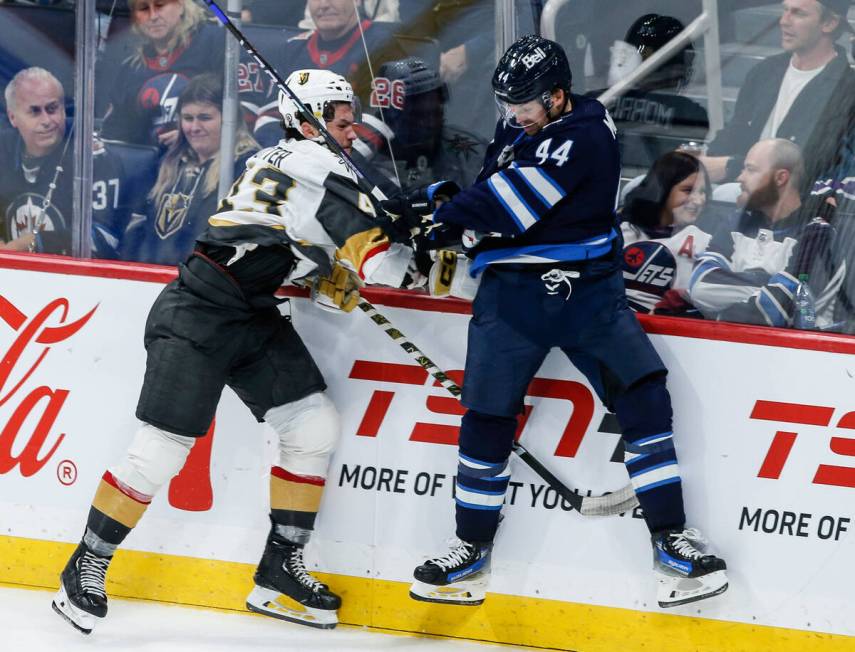 Winnipeg Jets' Josh Morrissey (44) and Vegas Golden Knights' Paul Cotter (43) collide during th ...