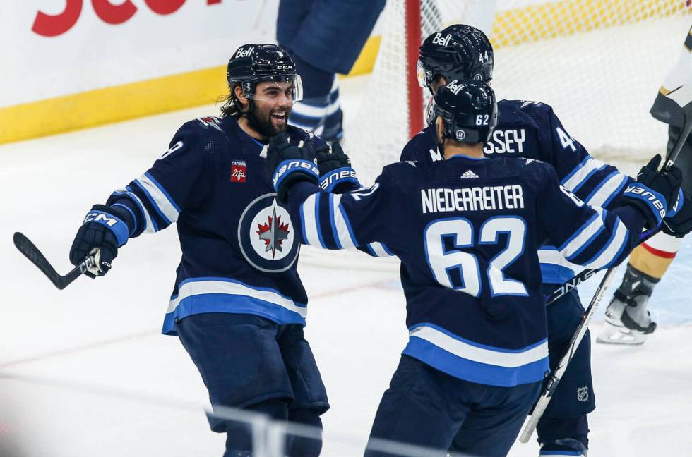 Winnipeg Jets' Alex Iafallo (9), Nino Niederreiter (62) and Josh Morrissey (44) celebrate Iafal ...