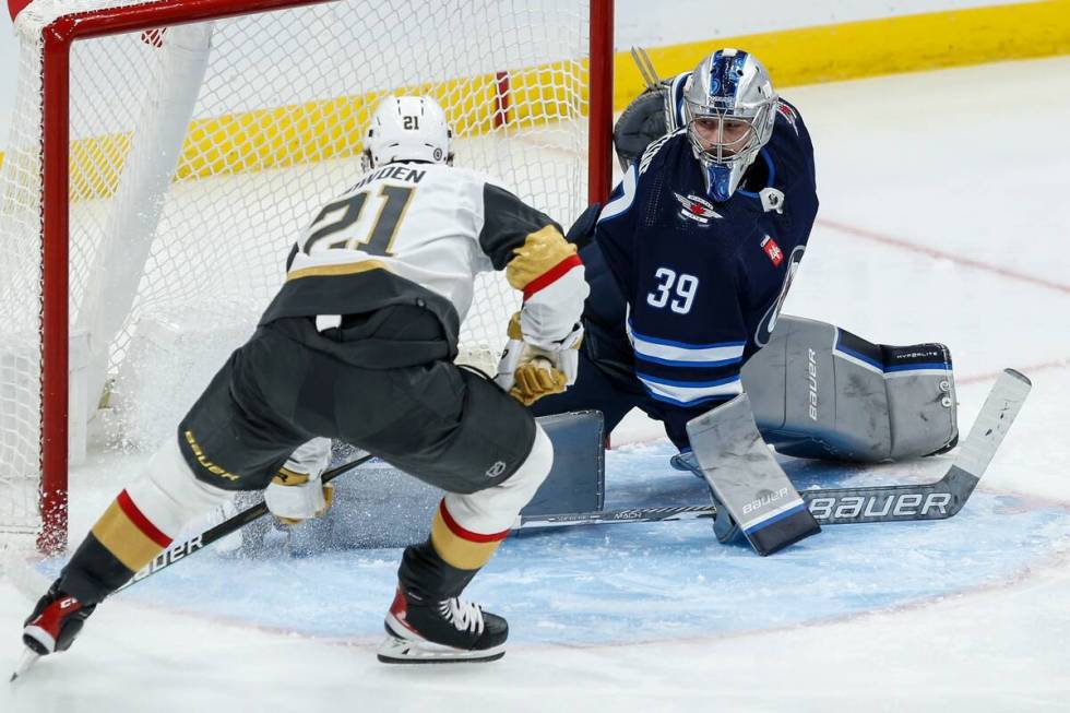 Vegas Golden Knights' Brett Howden (21) scores against Winnipeg Jets goaltender Laurent Brossoi ...