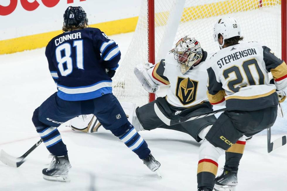 Vegas Golden Knights goaltender Logan Thompson, center, saves the shot from Winnipeg Jets' Kyle ...