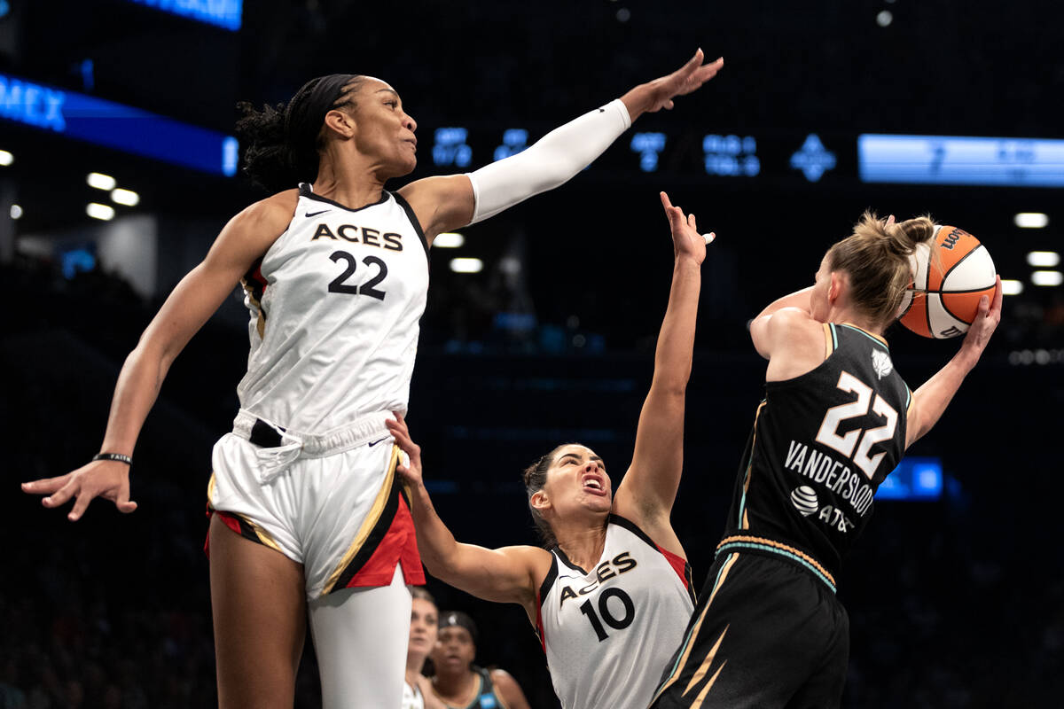 Las Vegas Aces forward A'ja Wilson (22) and guard Kelsey Plum (10) thwart a shot while New York ...