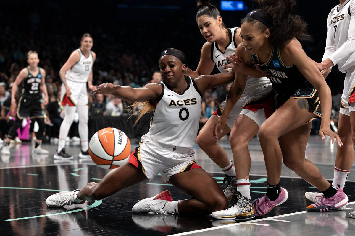 Las Vegas Aces guard Jackie Young (0) falls to the court while blocking a shot by New York Libe ...