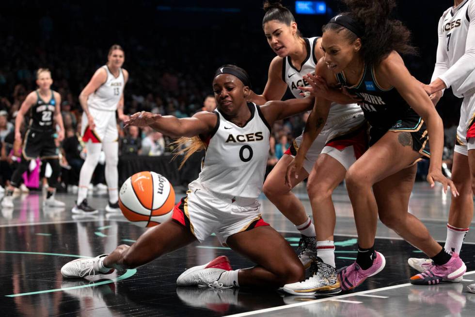 Las Vegas Aces guard Jackie Young (0) falls to the court while blocking a shot by New York Libe ...