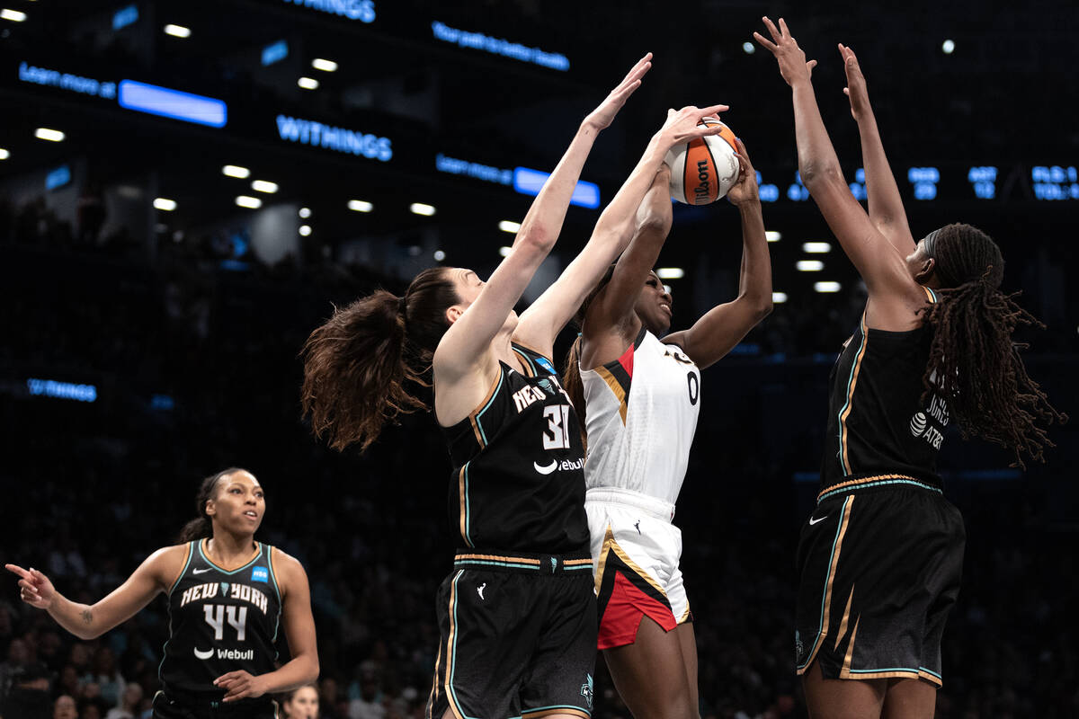 Las Vegas Aces guard Jackie Young (0) attempts to pass between New York Liberty forward Breanna ...