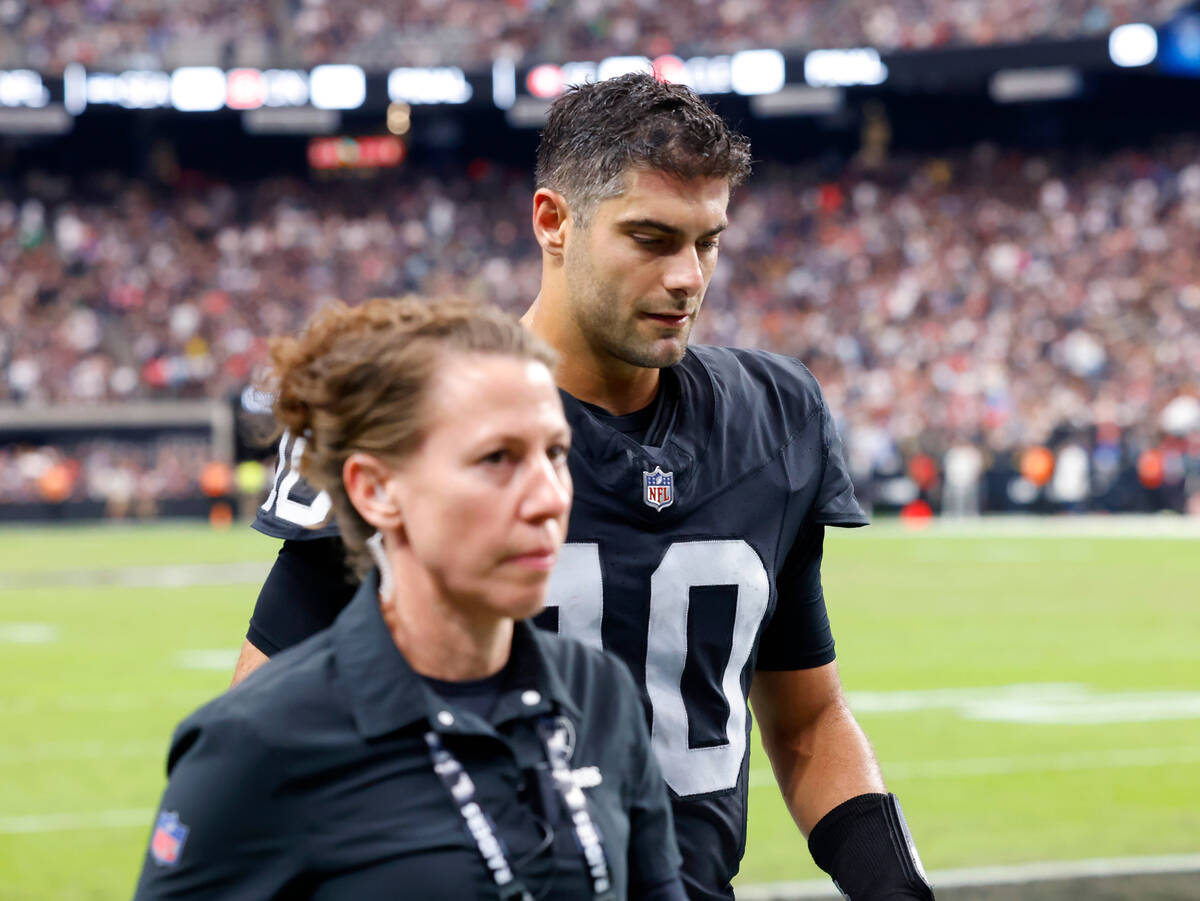 Raiders quarterback Jimmy Garoppolo (10) is escorted out of the field during an NFL football ga ...